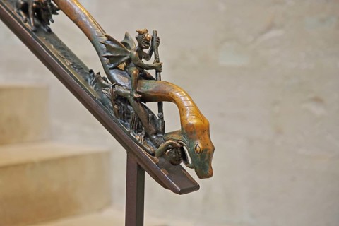 Handrail with sculpture and decorations, devil with wings riding on a snake, snake figure, snake
