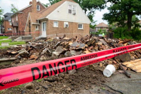 Detroit, Michigan - Signs warn of asbestos danger where a house was demolished. The house had been