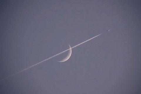 Evening sky with crescent moon and aeroplane, Germany