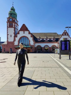Realistic artwork entitled Walking Woman by Sean Henry on the square in front of the railway