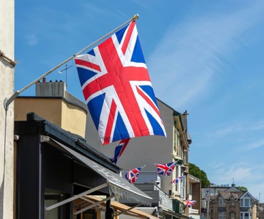 Union Jack flags on shops in street of historic buildings, The Strand, Dawlish, south Devon,