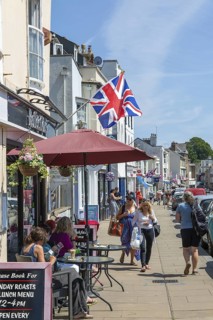 Union Jack flags on shops in street of historic buildings, The Strand, Dawlish, south Devon,