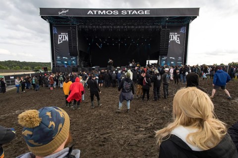 Festival visitors dance in the mud in front of the Atmos Stage at the Rock am Ring Festival on