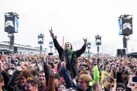 Festival visitor on shoulders with a French fries fork shaped like a hand at the Rock am Ring