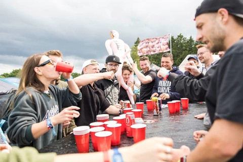 Festival visitors play a drinking game on a campsite at the Rock am Ring Festival on Saturday,