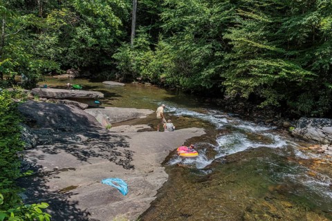 Senior couple watches children floating down the Hiawassee River on inflatable rafts near