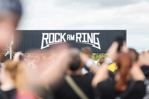 Festival visitors in front of a container with Rock am Ring logo at the Rock am Ring Festival on