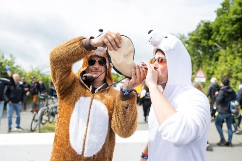 Two festival visitors in animal costumes drink from a horn at the Rock am Ring festival on Friday,