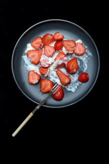 Sliced strawberries and whipped cream on a plate, dessert