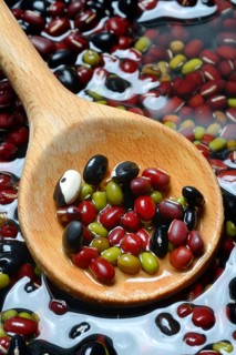 Dried beans placed in water to soak, wooden spoon