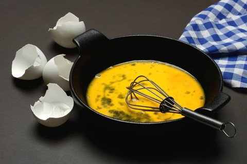 Cracked egg in a pan, hen's egg and eggshells