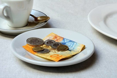 Tip, Swiss coins and Swiss franc note on plate, Switzerland