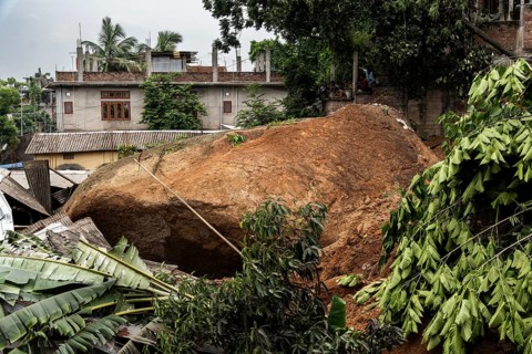 Large rock slides from the top of a hill and damaged houses in a major landslide, triggered by a