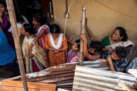 Residents looks as Rescue operations by the National Disaster Response Force (NDRF) and police are
