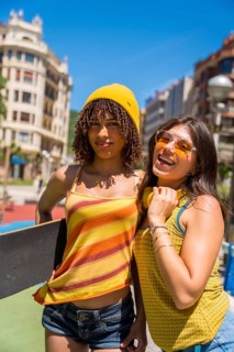 Two female friends enjoying a sunny day in the city, showcasing their youthful energy and urban