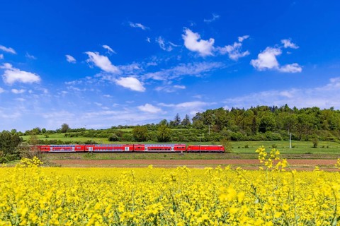 RegionalExpress RE5 en route on the Swabian Alb. Landscape along the railway line in spring.