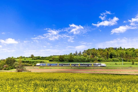 Regional train travelling on the Swabian Alb. Landscape on the railway line in spring. Lonsee,