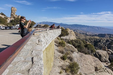 Travellers look out over the Catalina Mountains and the city of Tuscon at the Windy Point Vista