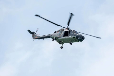 Naval helicopter flies in front of a clear sky, majestic and technical, Prerow,