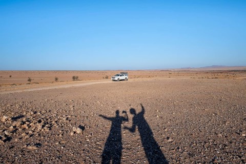 Shadow of two people, holiday, off-road car on a sandy track, Brandberg, Damaraland, Namibia