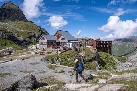 Mountaineer in front of mountain hut Cabane de Prafleuri in mountain landscape, Valais, Western