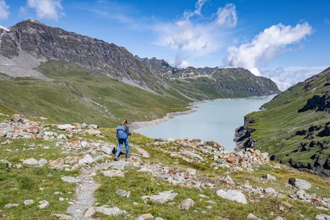 Mountaineer on a hiking trail in an idyllic mountain landscape, Lac des Dix reservoir in the