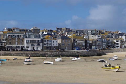 A busy coastal harbour with many boats and a town with densely built houses, St Ives, Cornwall,