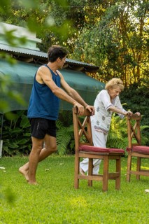 Young male physiotherapist assisting a senior woman performing rehabilitation exercises using