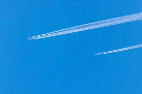 Two aeroplanes with vapour trails in the bright blue sky, Ternitz, Lower Austria, Austria