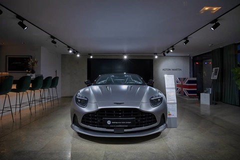 View through shop window to showroom, interior shot, sales exhibition of the car brand Aston