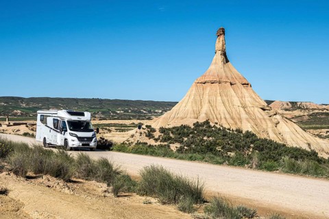 Camper van on gravel road, Castildetierra rock formation, semi-desert, Bardena Blanca area,