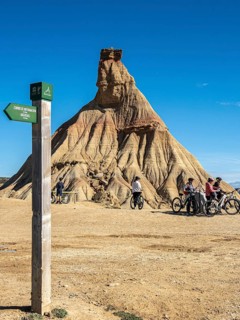 Group of cyclists, Castildetierra rock formation, semi-desert, Bardena Blanca area, Bardenas Reales