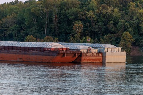 Deck hands place the American flag on a barge being pushed on the Tennessee River near Savannah,