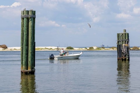 Two men on a fishing boat in Mobile Bay along the coast of Dauphin Island in Alabama