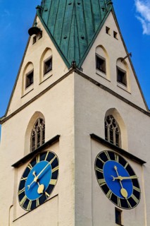 Tower with two large clocks and a green roof under a blue sky, The town of Kempten im Allgäu