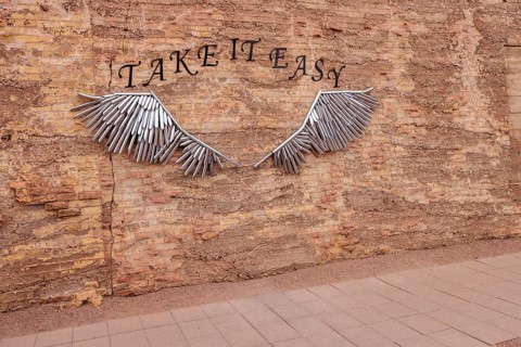 Metal tubular art on brick wall for tourists to pose for pictures at Standin' on the Corner Park in