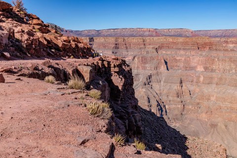 Visitors walk along the canyon rim to the location of the old mining cable structure at Guano Point