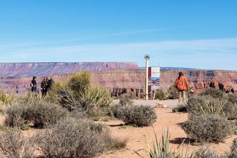 Native American security officer standing by sign with information about Eagle Point observation