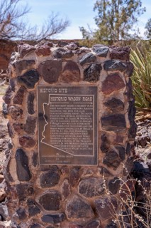 Plaque on stone historical marker provides information on the historic wagon road through Arizona
