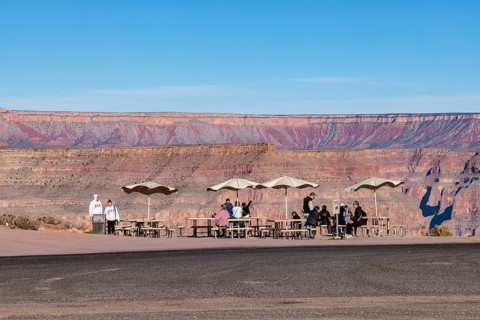 Tourists waiting for bus transportation at covered picnic tables at Guano Point in Grand Canyon