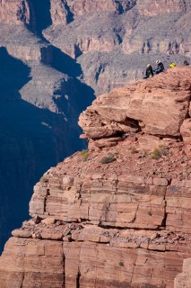 Visitors climb on rock formation rising above the canyon at Guano Point in Grand Canyon West near
