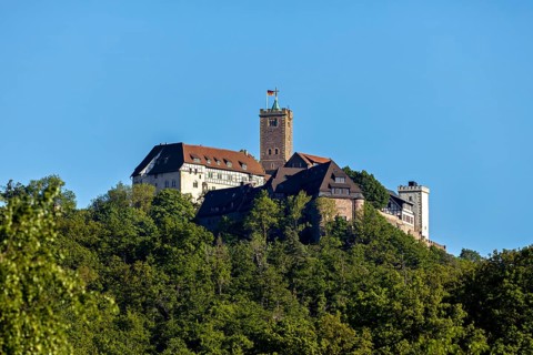 Castle on a green hill under a bright sky, Wartburg Castle near Eisenach in Thuringia