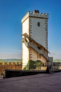 White watchtower with external staircase under a blue sky, Wartburg Castle near Eisenach in