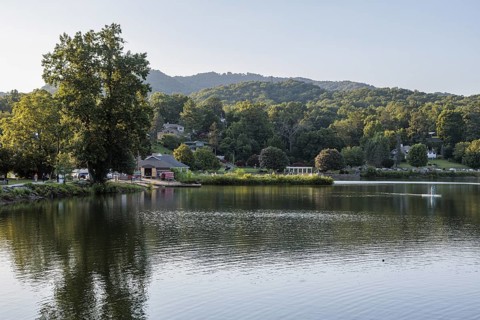 Youth paddles his paddleboard away from Lake Junaluska Outfitters launch in Lake Junaluska, North