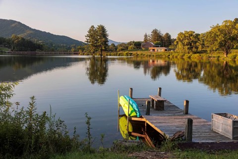 Private pier with a bench, kayak and paddleboard on the lake at Lake Junaluska, North Carolina