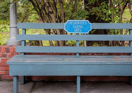 Wooden bench with sign for Designated Vaping Area at the Dollywood amusement park in Pigeon Forge,