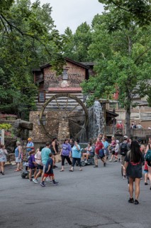 Park guests walking past the Dollywood Grist Mill at the Dollywood amusement park in Pigeon Forge,