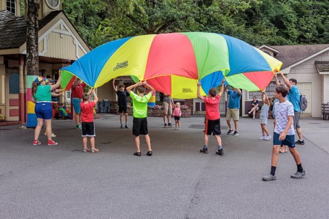 Children play with a parachute at the Dollywood amusement park in Pigeon Forge, TN