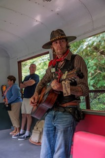 Singer and entertainer travels from car to car singing songs to the passengers for tips on the