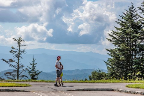 Visitors look out over the smoky haze on the mountainsides at an overlook along the Blue Ridge